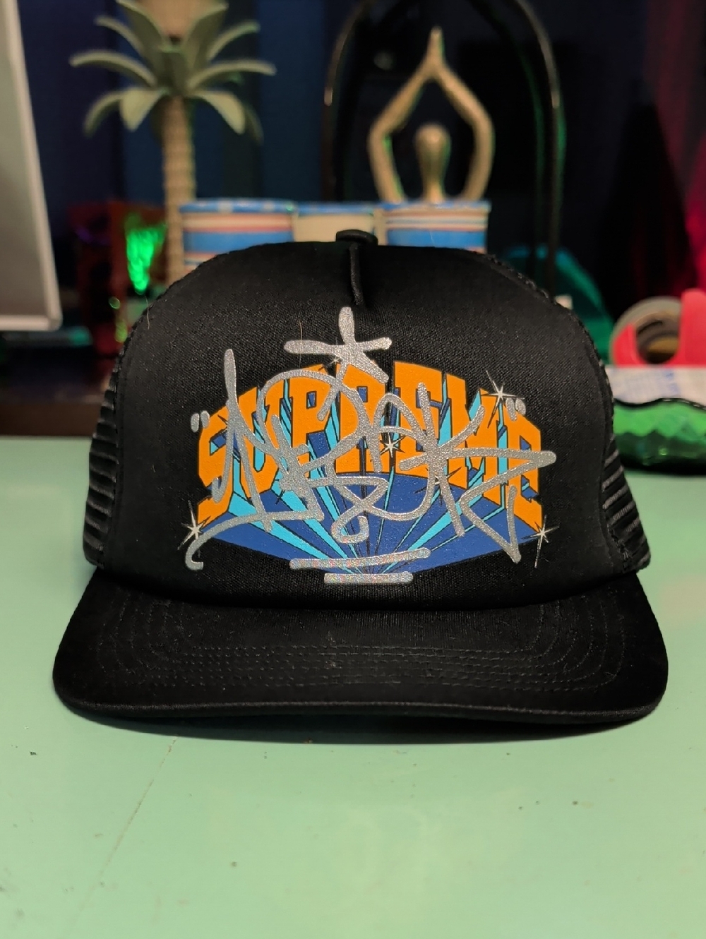 Supreme Black Trucker Hat with Orange and Blue Graphic